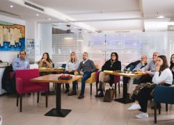 School teachers and principals attending a course on adult education sitting in a conference room listening to a lecture.