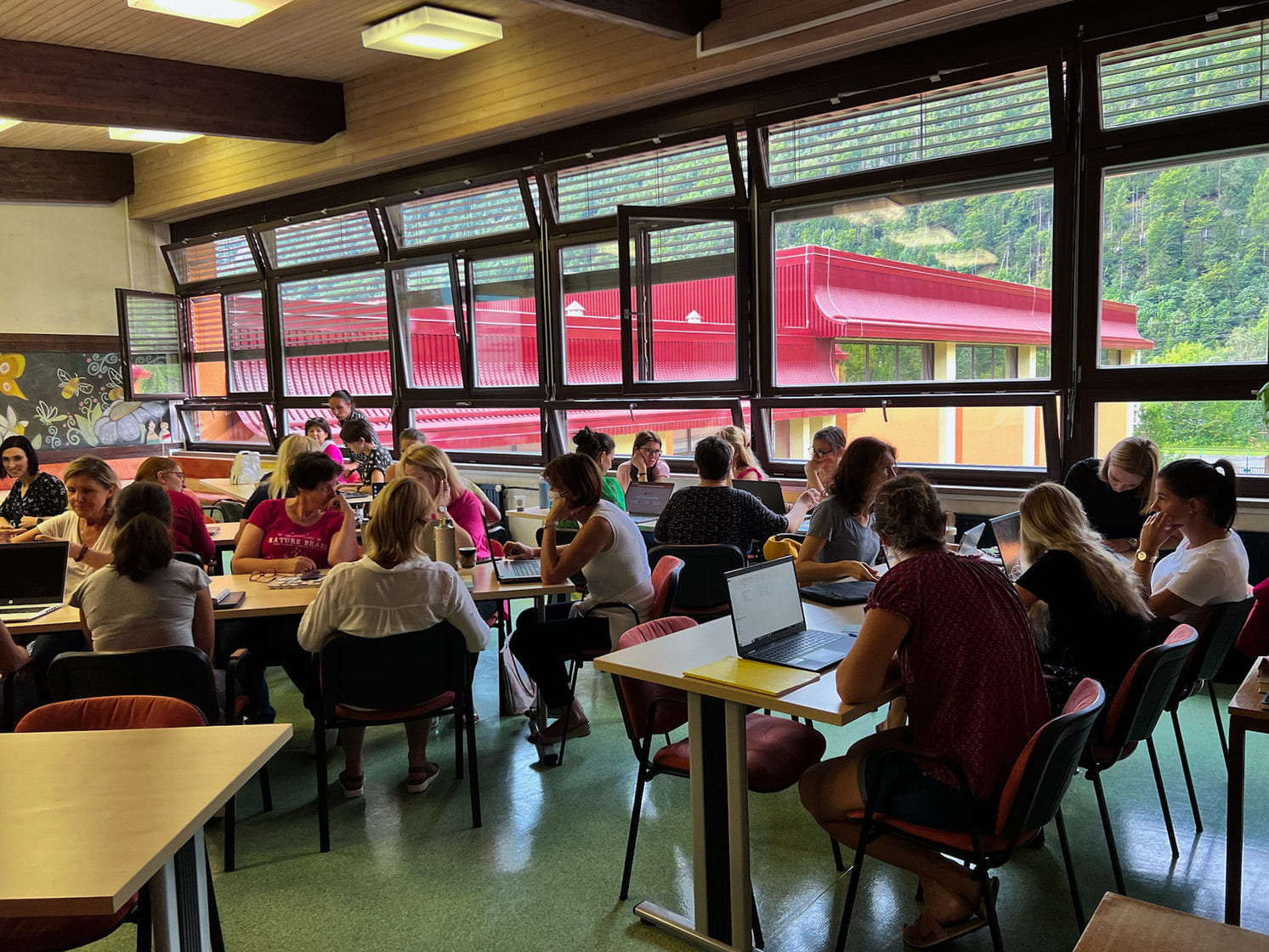 A group of teachers sitting in a large classroom enjoying their teacher training session