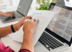 a teacher sitting at a laptop preparing a lesson plan using AI