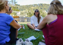 Teachers sitting on the grass during an outdoor mindfulness and well-being session in Split
